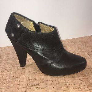 Black leather ankle bootie with gunmetal studs.